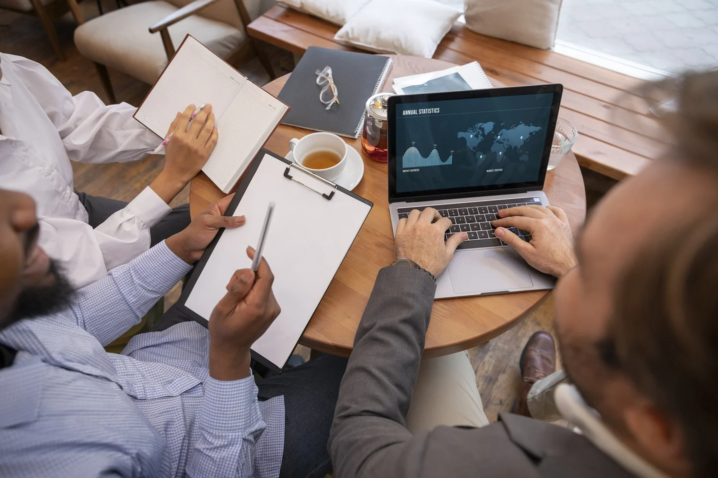 Colleagues reviewing a chart on a laptop and printed business documents