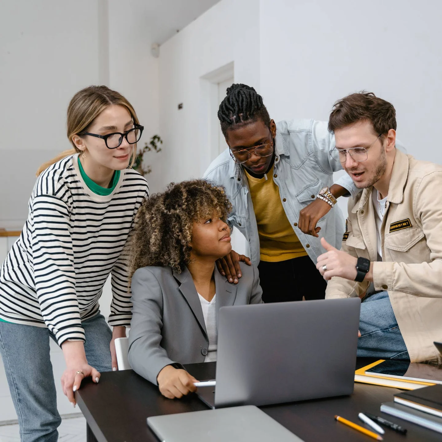 A group of colleagues collaborating around a laptop
